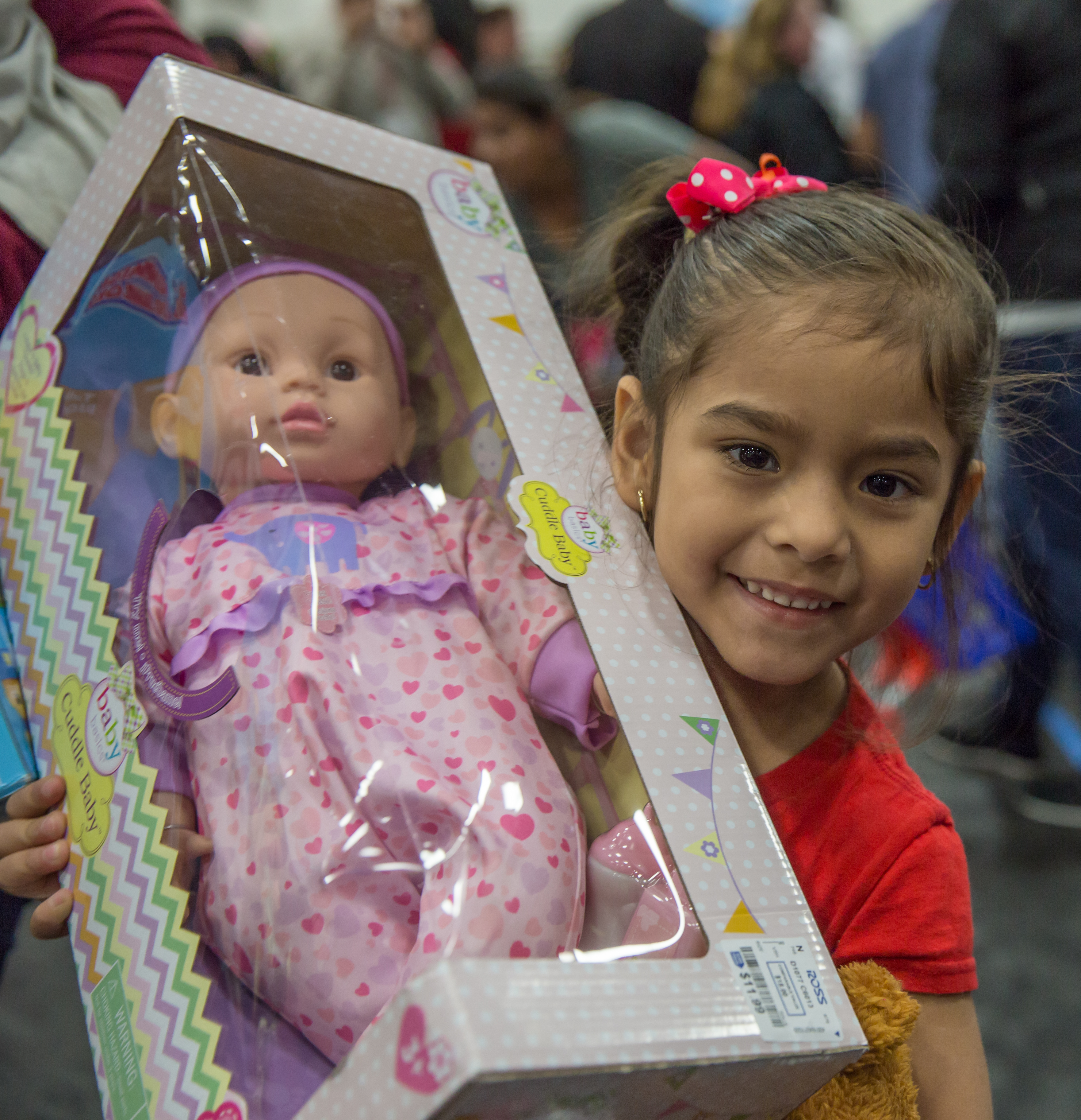 Happy girl holding a toy baby doll